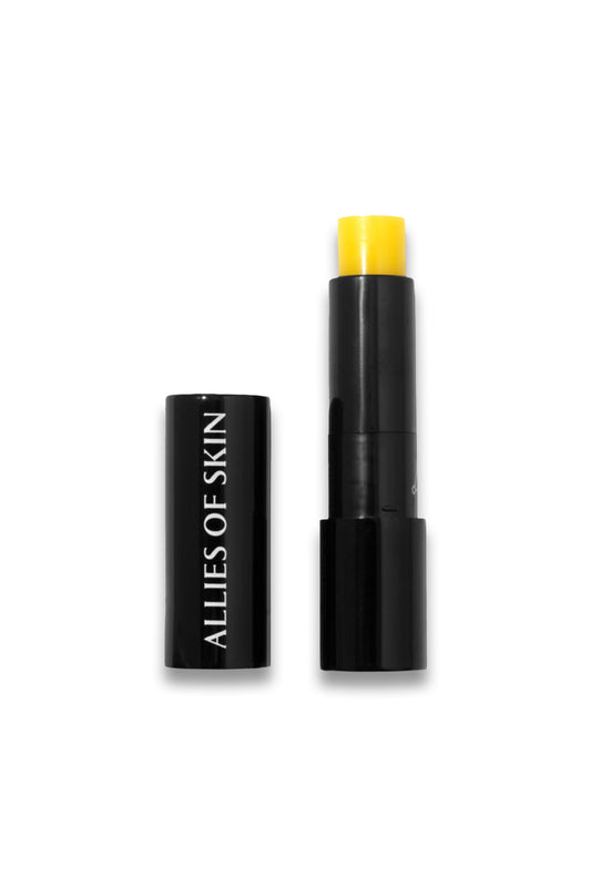Black cosmetic stick with yellow cap on a white background, branded 'Allies of Skin'.